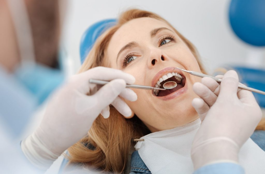 A dentist examining a female patient's teeth after cleaning them